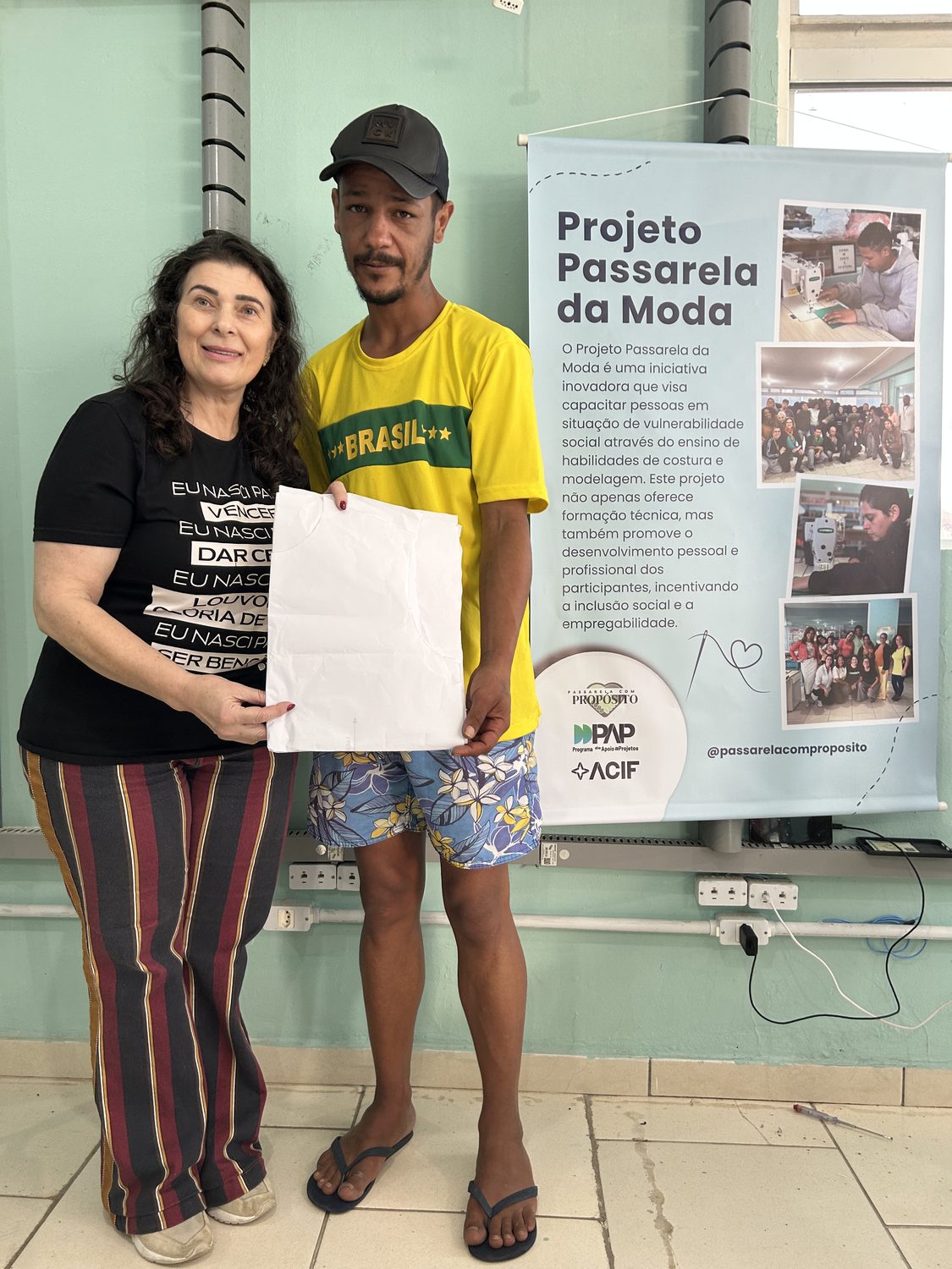 Participante exibindo peça finalizada ao lado do banner